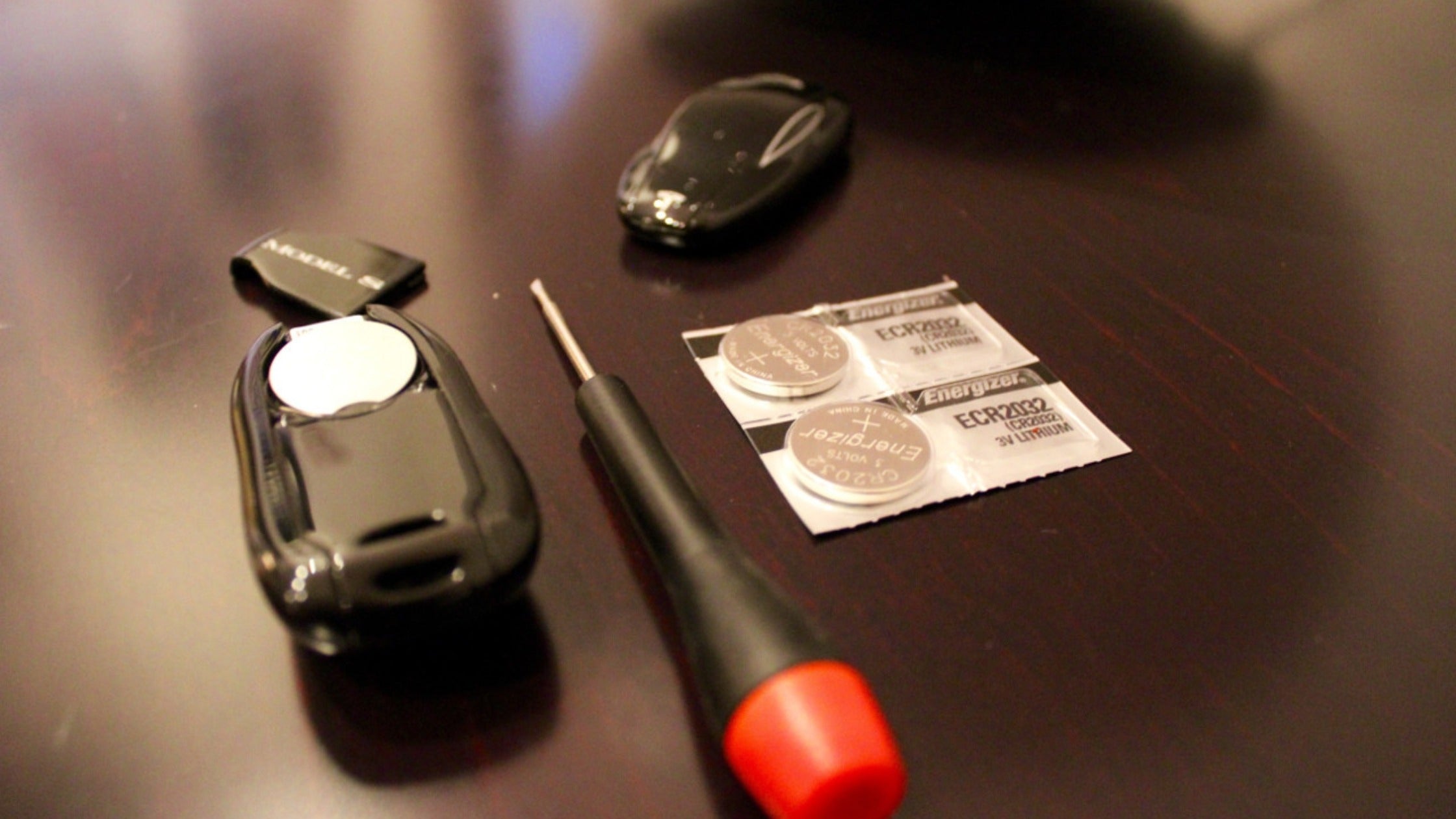 Tesla key fobs for Model S, 3, X, and Y showing battery replacement tutorial with CR2032 battery comparison guide