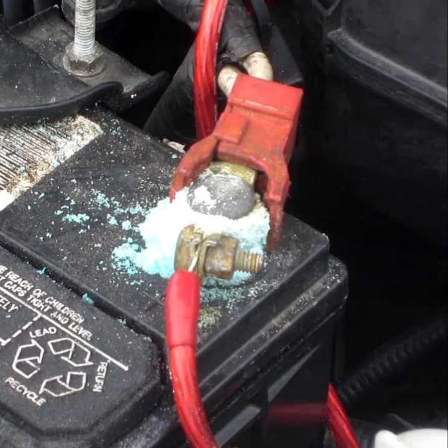 Person cleaning car battery terminals