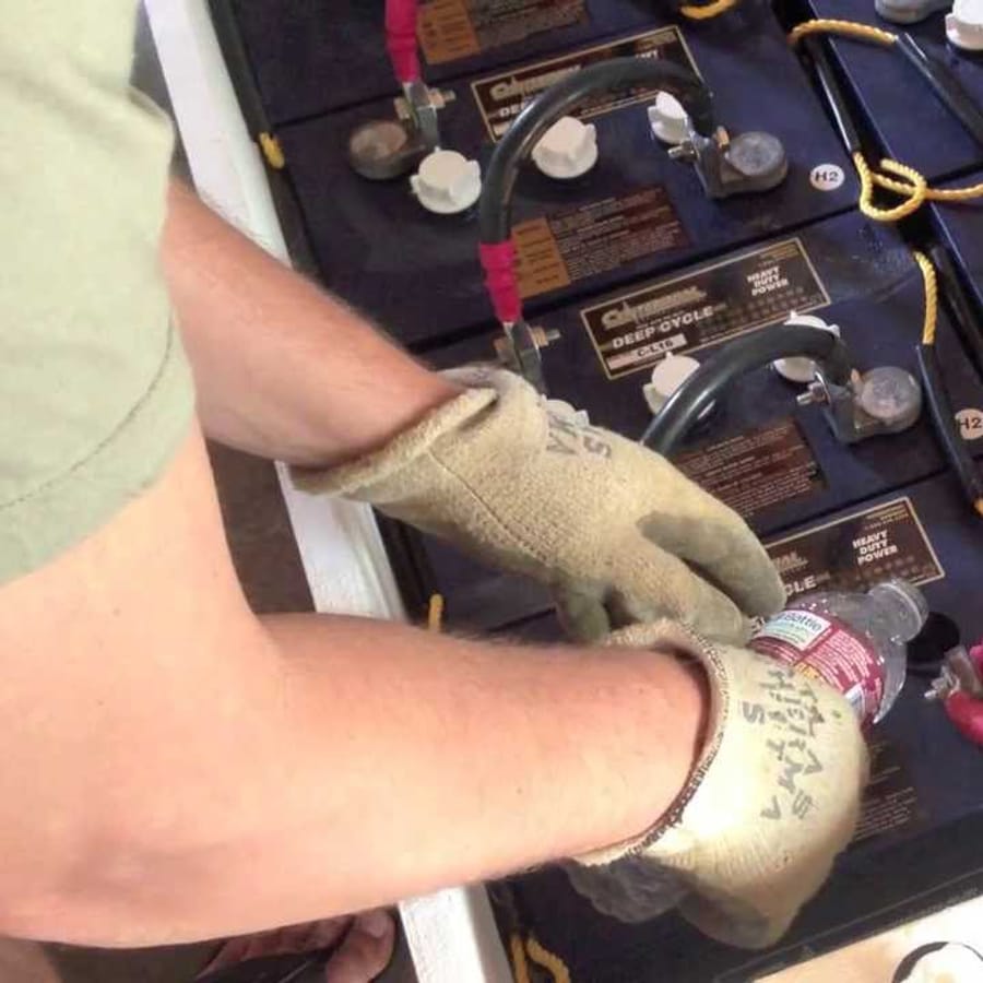 Technician maintaining a solar energy storage battery