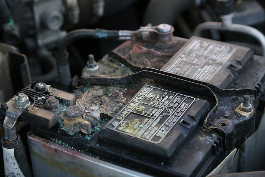 Signs of a failing car battery including dim headlights, slow engine crank, and warning lights on dashboard